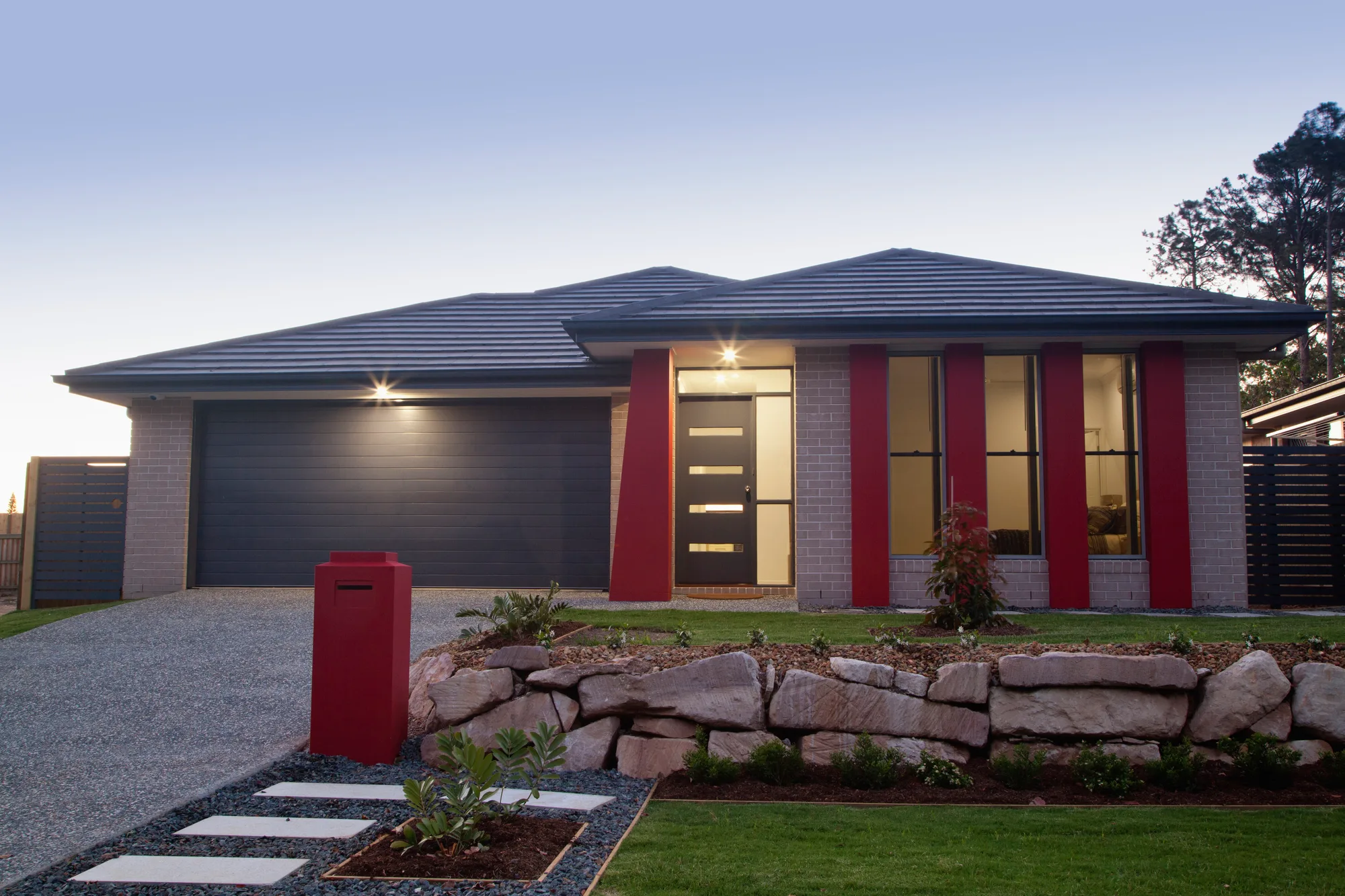 Concrete driveway beside a landscaped rock garden