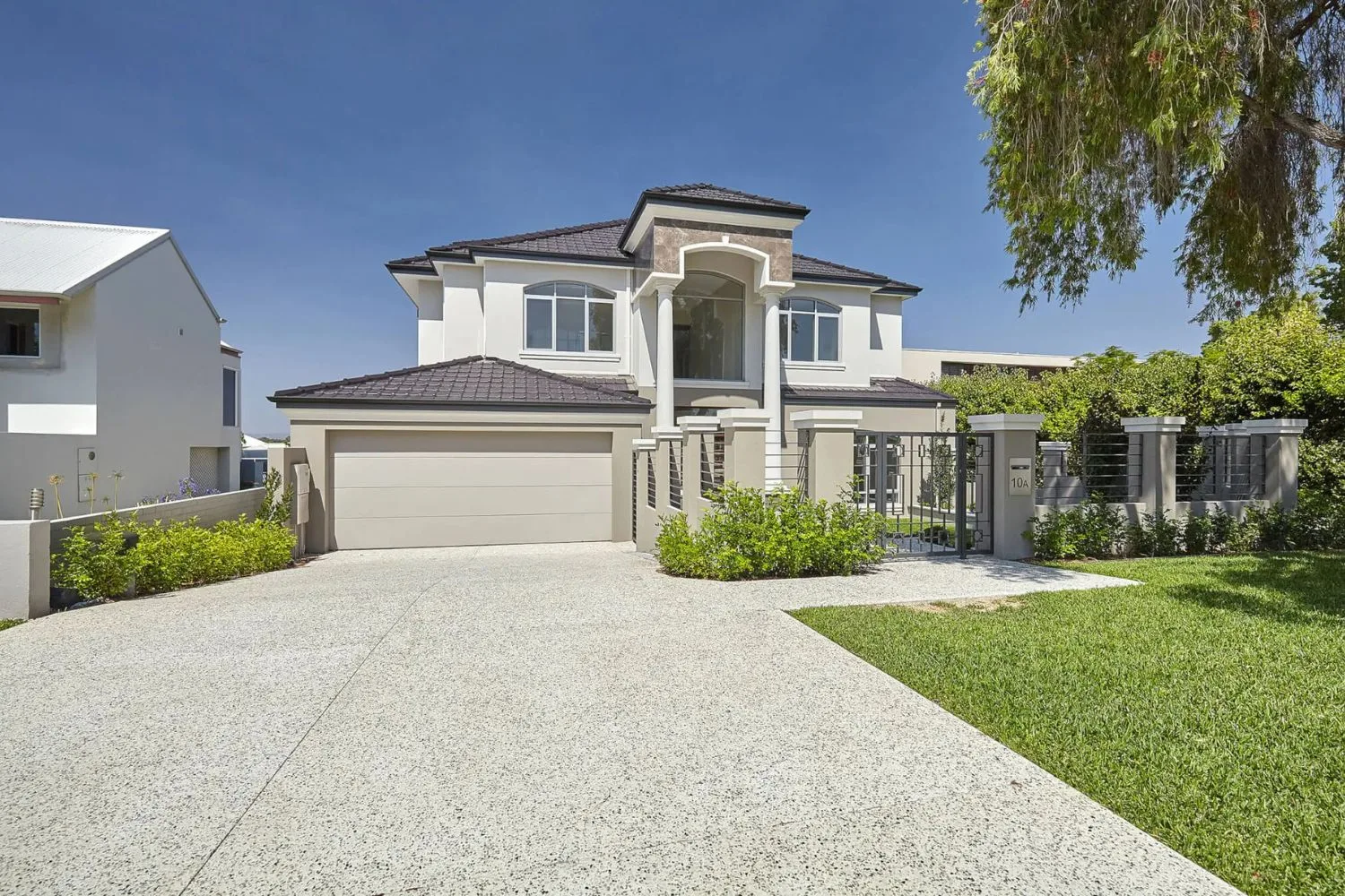 Exposed aggregate concrete driveway leading to a double garage