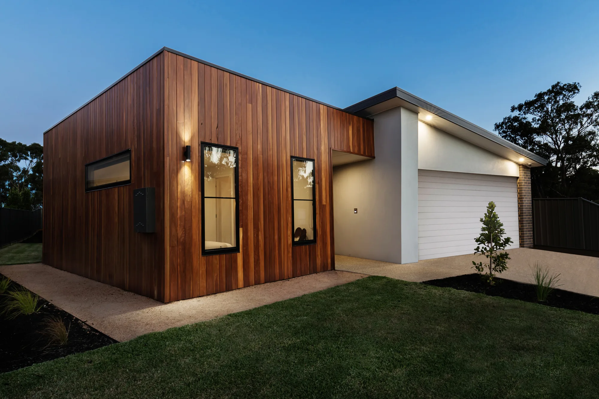 Concrete path and slab around a modern timber-clad home
