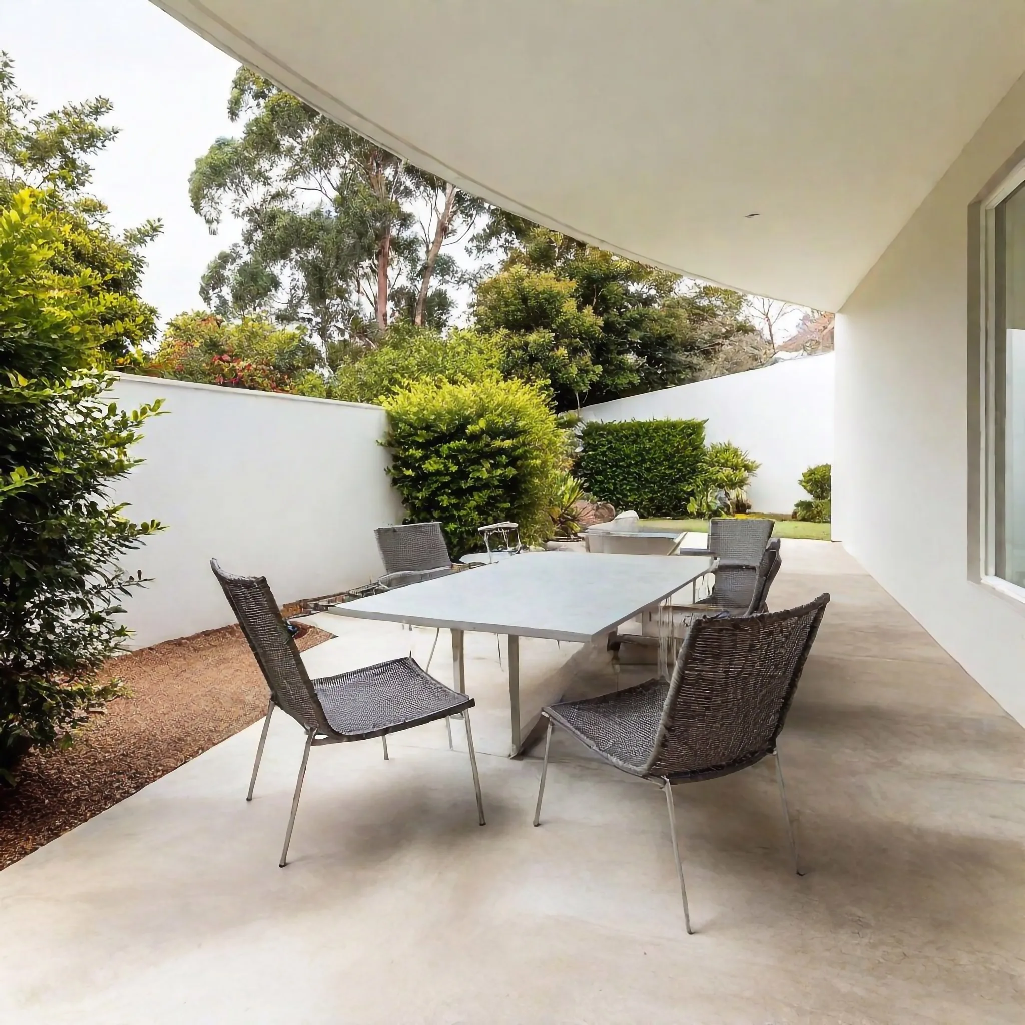 Concrete courtyard patio with outdoor table and chairs