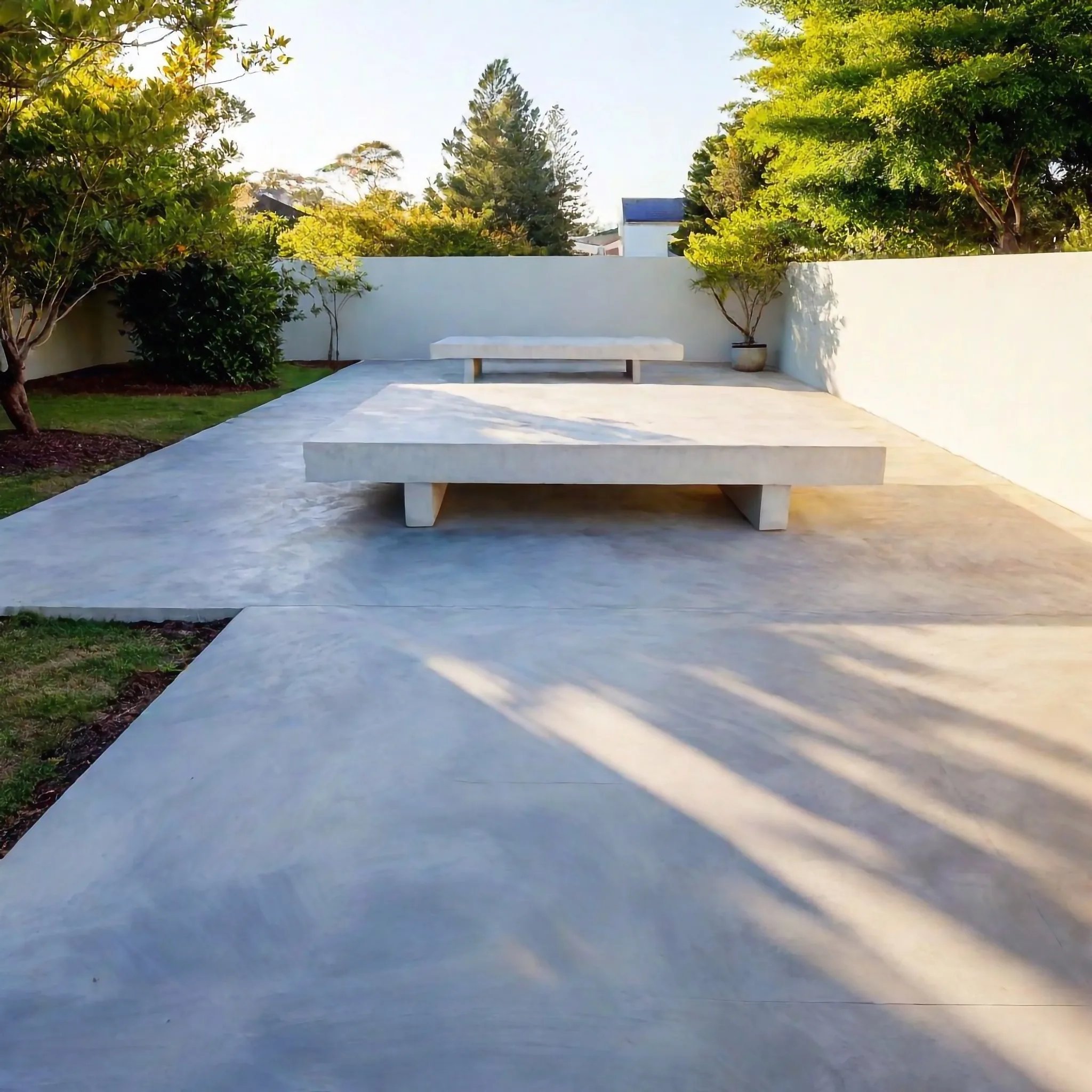 Large concrete patio with a built-in concrete bench
