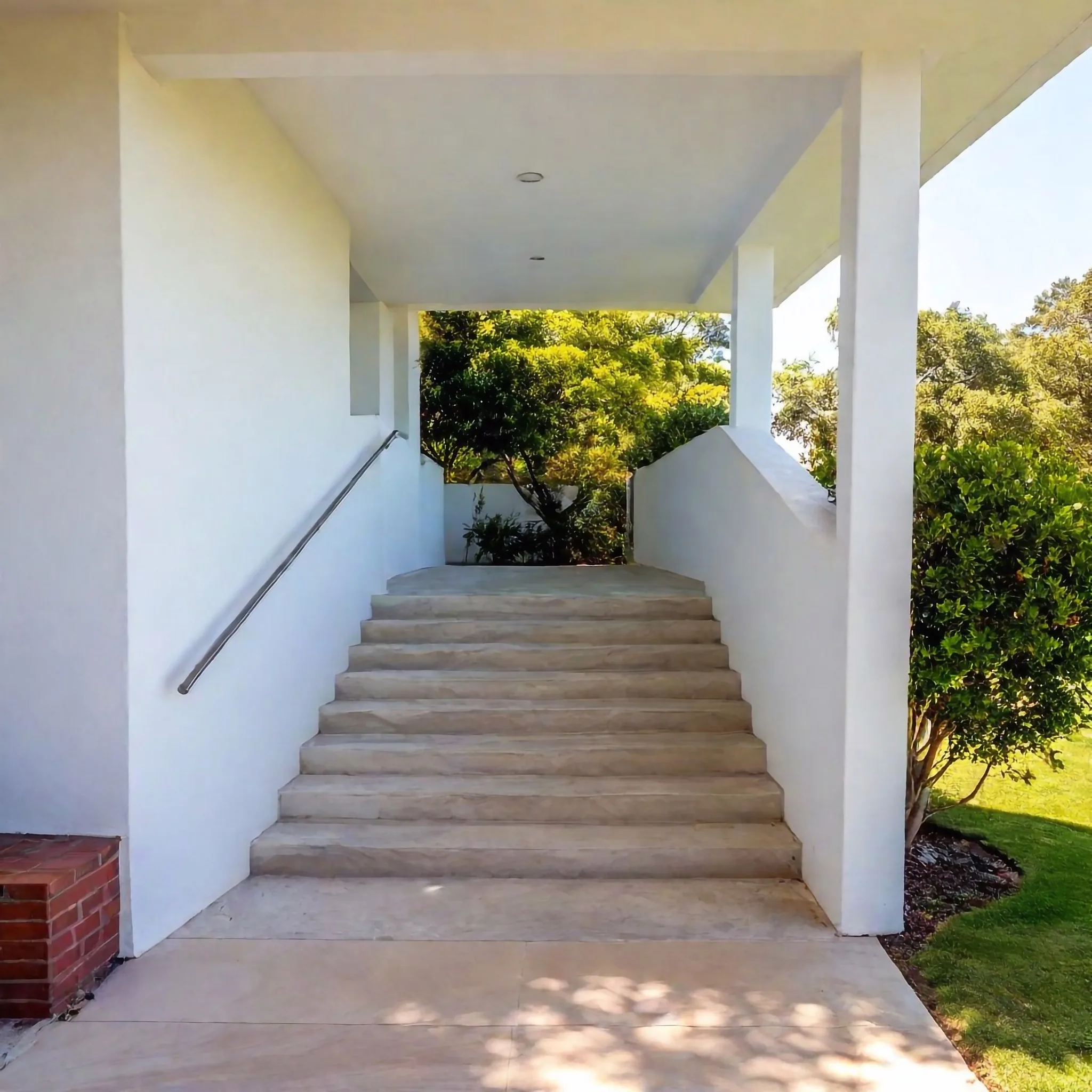 Wide concrete entrance stairs under a covered walkway