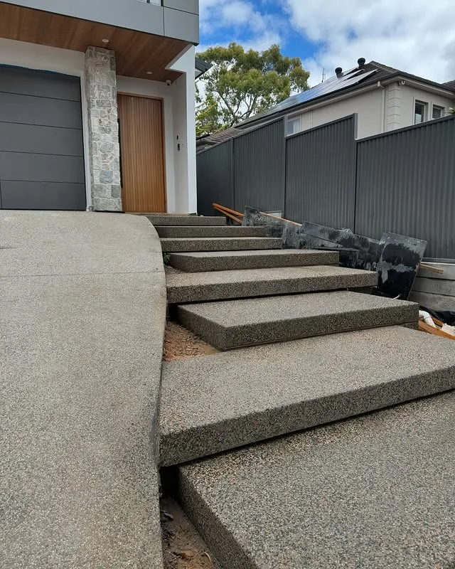 Exposed aggregate concrete steps leading to a front door