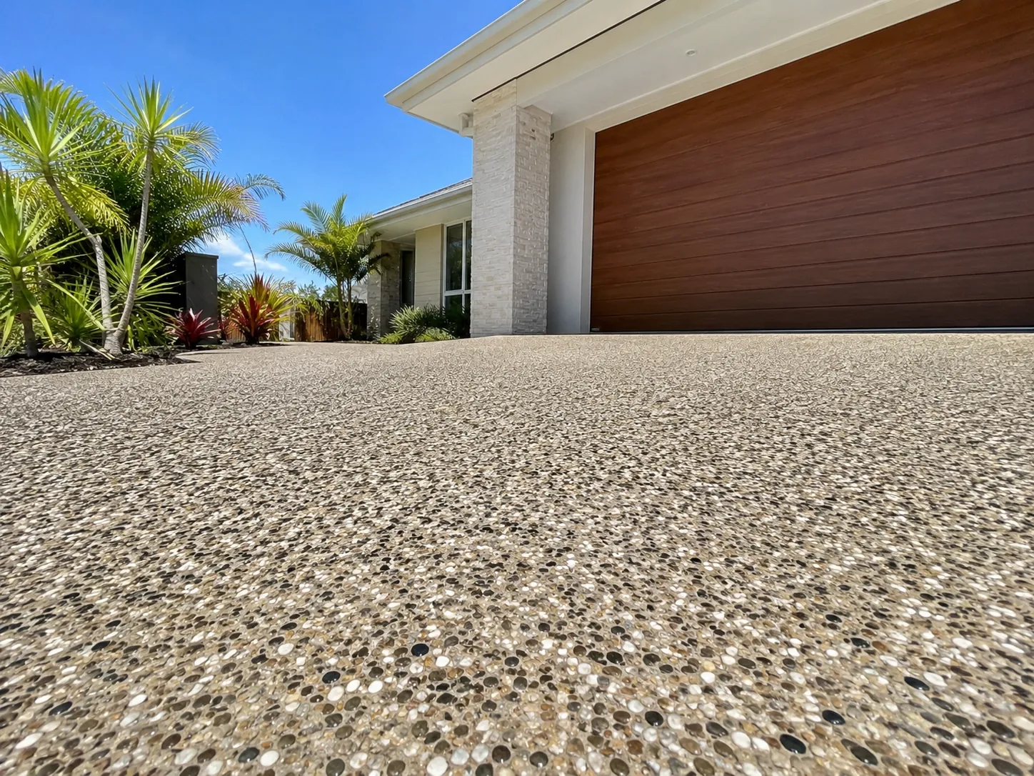 Exposed aggregate driveway in front of a timber garage door