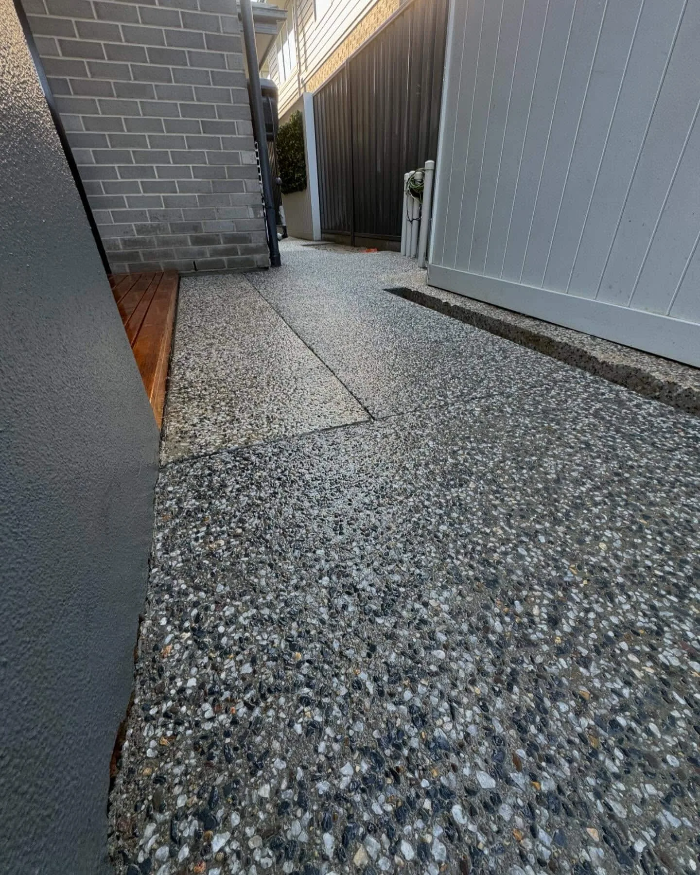 Exposed aggregate side path running along a house