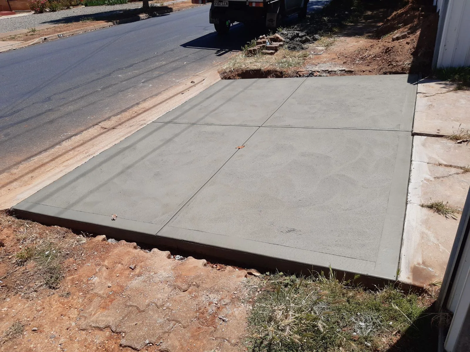 Plain concrete driveway apron poured at the kerb